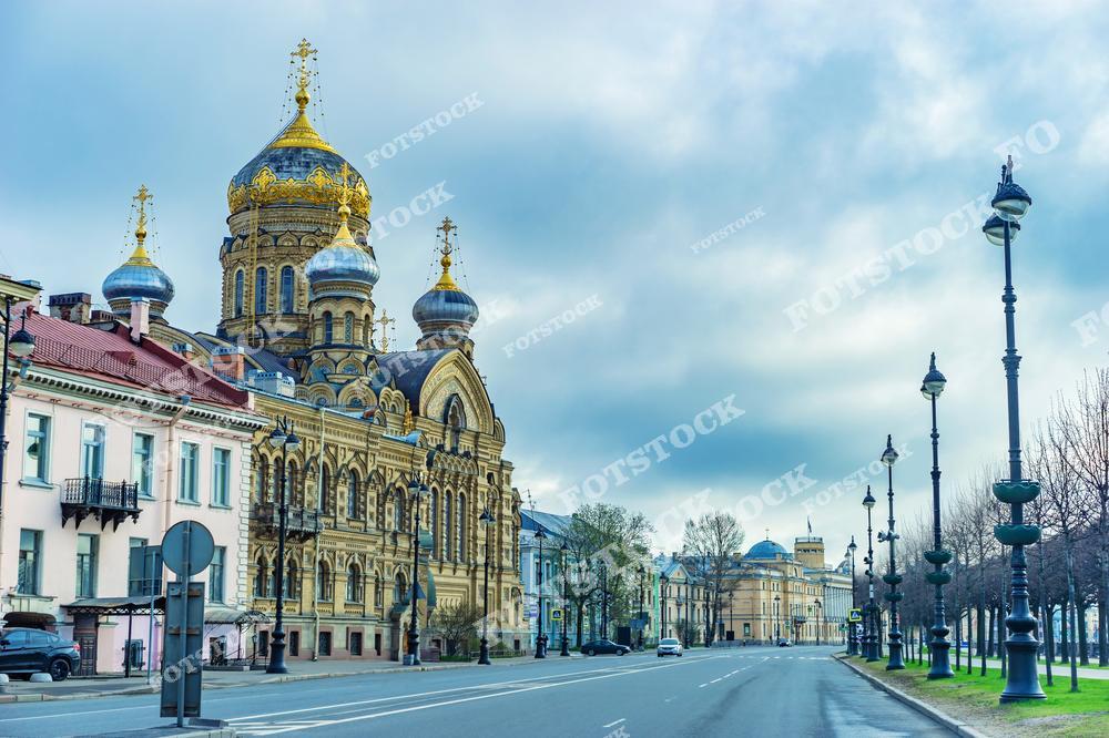 На снимке изображена Церковь Успения Пресвятой Богородицы на Васильевском острове — один из ярких образцов православной архитектуры Санкт-Петербурга. Храм с его золотыми куполами и изысканными фасадами является важной исторической достопримечательностью города. Спокойная атмосфера утра и пустынная улица подчеркивают торжественность и красоту этой церкви.
